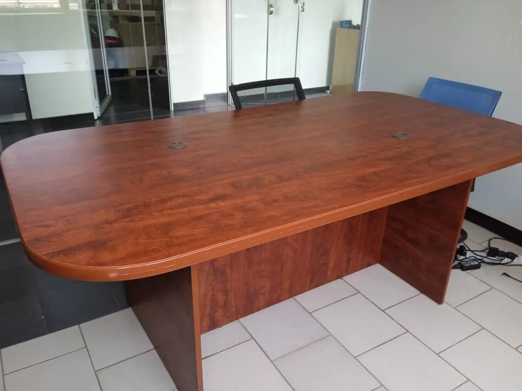 Office Conference Table: The conference table is a oval shaped wooden table and it features a lamina